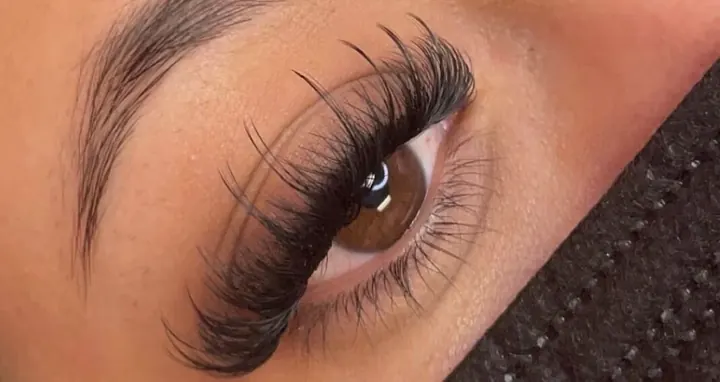 Close-up of a dramatic, textured wispy lash set with long spikes on a brown eye