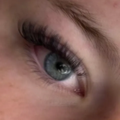 A soft, natural-looking lash set on a blue-grey eye